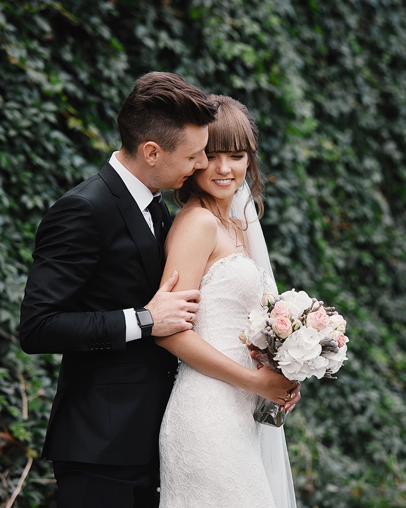 Wedding couple against greenery backdrop